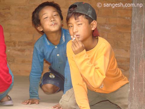 Young boys posing for the camera while they smoke